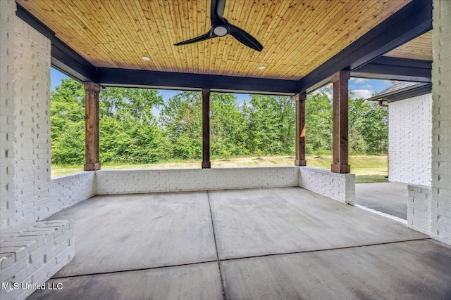 unfurnished sunroom featuring wood ceiling, ceiling fan, and concrete floors