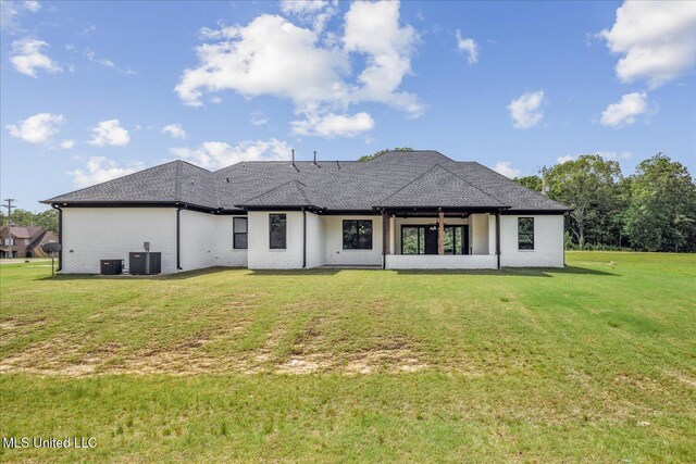 back of house with a lawn, central AC, and roof with shingles