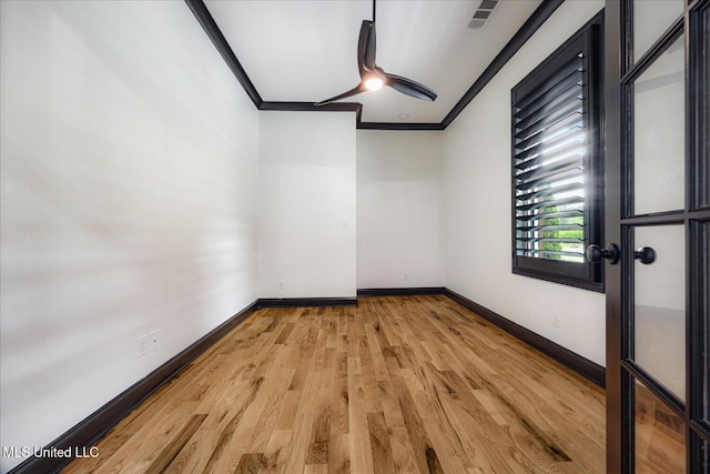 unfurnished room featuring ceiling fan, visible vents, light wood-type flooring, baseboards, and ornamental molding