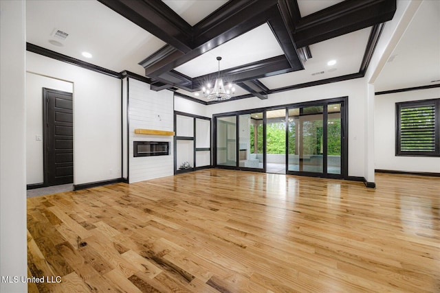 unfurnished living room with a chandelier, ornamental molding, and wood finished floors