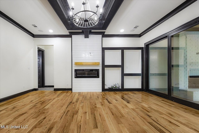 interior space featuring light wood finished floors, a chandelier, baseboards, visible vents, and ornamental molding