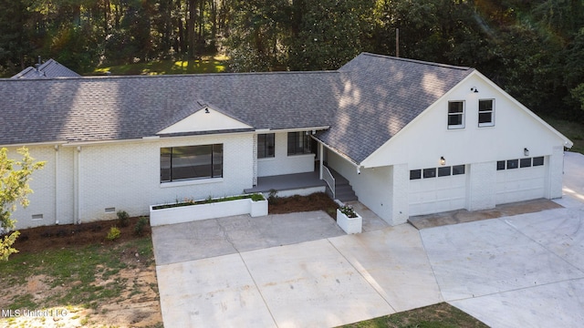 112 Louis Wilson Dr, Brandon, MS 39042 - view of front of property featuring a shingled roof, a garage, concrete driveway, brick siding, and covered porch