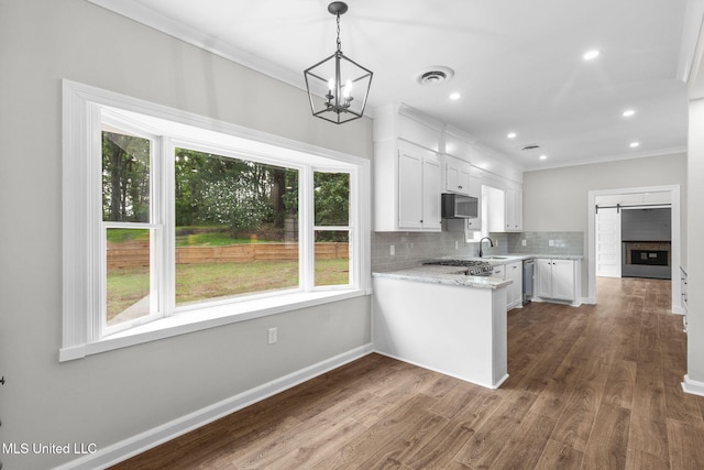 112 Louis Wilson Dr, Brandon, MS 39042 - kitchen featuring ornamental molding, white cabinetry, backsplash, dark wood-style flooring, and a chandelier