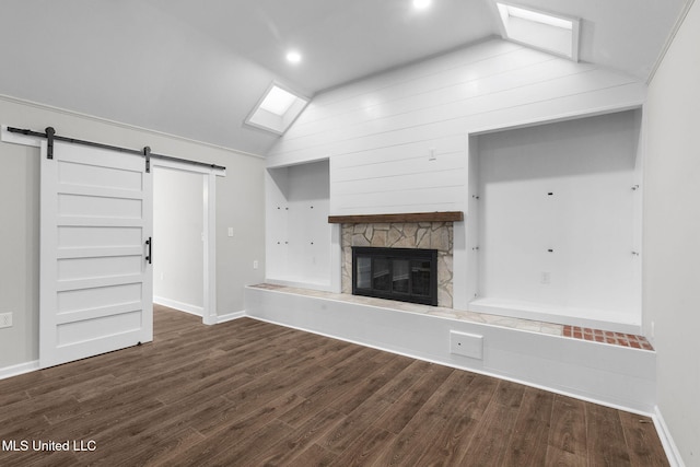 112 Louis Wilson Dr, Brandon, MS 39042 - unfurnished living room featuring vaulted ceiling, a barn door, dark wood-type flooring, a skylight, and a fireplace