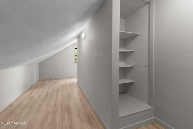 112 Louis Wilson Dr, Brandon, MS 39042 - bonus room with a textured ceiling, wood finished floors, and lofted ceiling