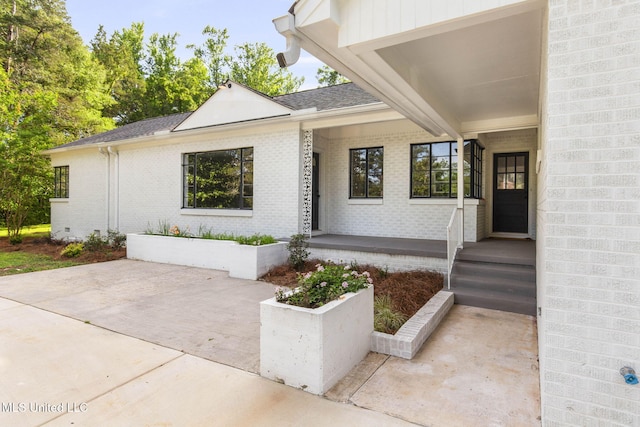 112 Louis Wilson Dr, Brandon, MS 39042 - doorway to property featuring brick siding, a shingled roof, and a patio