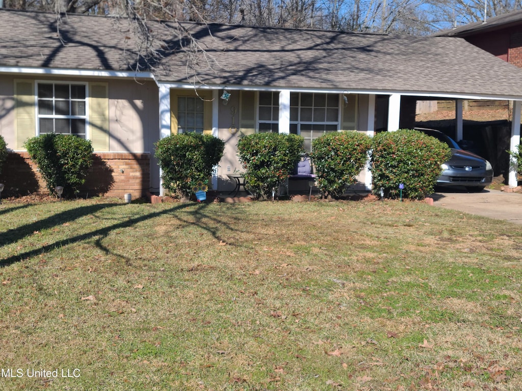 view of front of house with a carport and a front yard