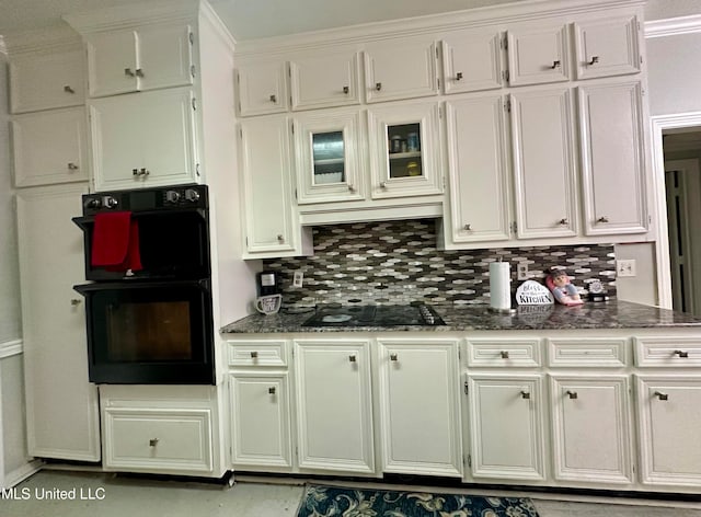 kitchen with decorative backsplash, dark stone countertops, ornamental molding, black appliances, and white cabinets