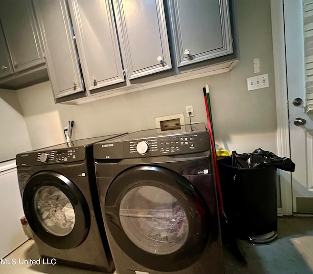 clothes washing area with independent washer and dryer and cabinets