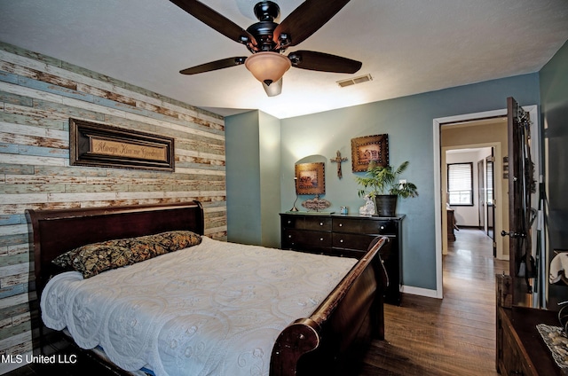 100 Eager St Unit C, Clinton, MS 39056 - bedroom with an accent wall, dark wood-style flooring, wooden walls, and ceiling fan