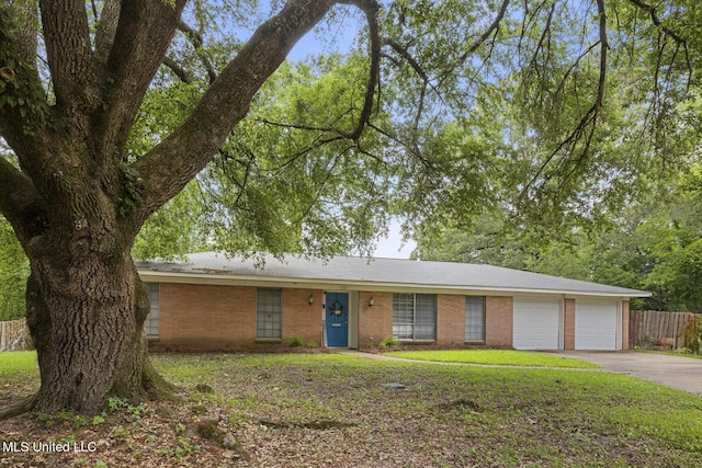 ranch-style house with a garage, aphalt driveway, fence, a front yard, and brick siding