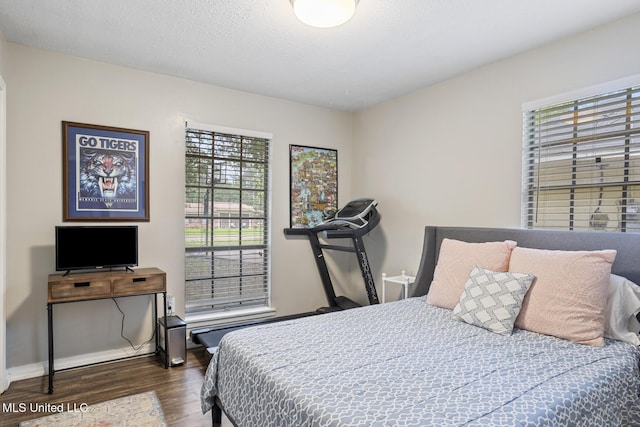 bedroom with dark wood-style flooring