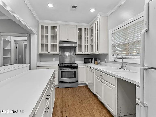 kitchen featuring white cabinets, a sink, appliances with stainless steel finishes, under cabinet range hood, and recessed lighting