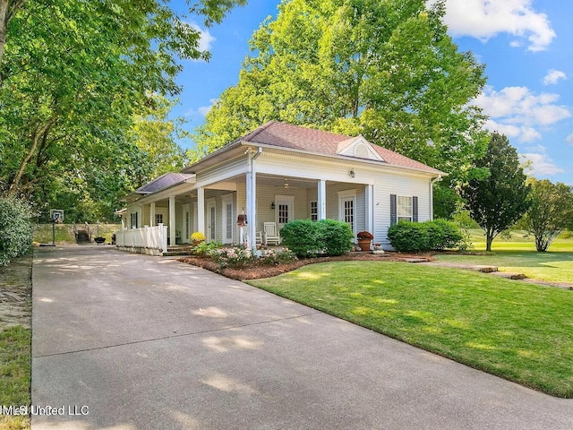 view of front of home with a porch, roof with shingles, driveway, and a front lawn
