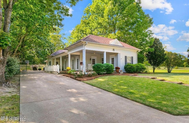 view of front facade with roof with shingles, driveway, a front lawn, and covered porch