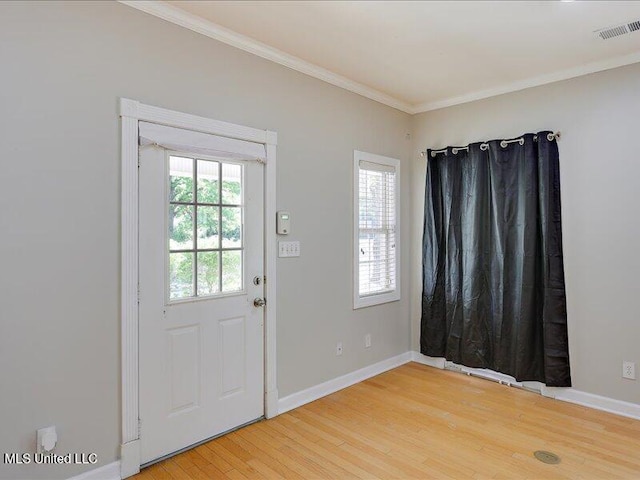 entryway featuring ornamental molding, visible vents, light wood-style flooring, and baseboards
