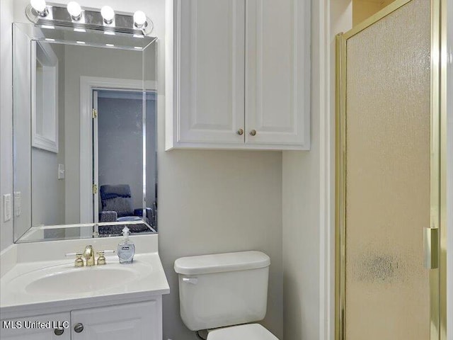 full bathroom with vanity, an enclosed shower, and toilet