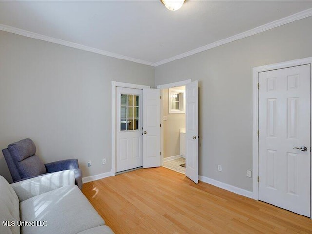 sitting room with light wood finished floors, baseboards, and crown molding