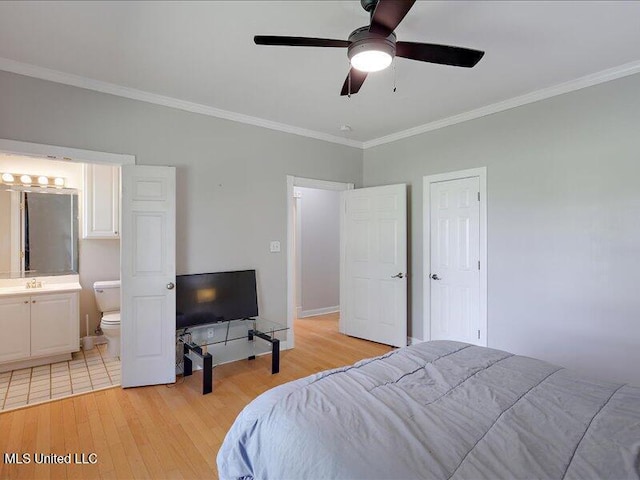 bedroom featuring light wood-type flooring, crown molding, a ceiling fan, and ensuite bath
