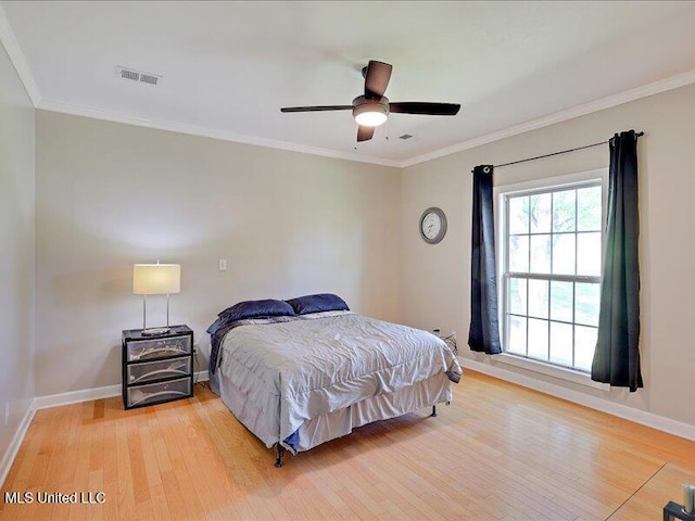 bedroom featuring ornamental molding, visible vents, light wood-style flooring, and baseboards