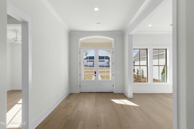 doorway with french doors, light wood-type flooring, ceiling fan, and ornamental molding