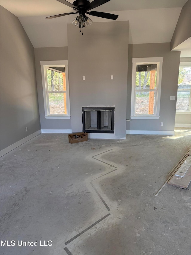 unfurnished living room featuring ceiling fan, lofted ceiling, and a fireplace