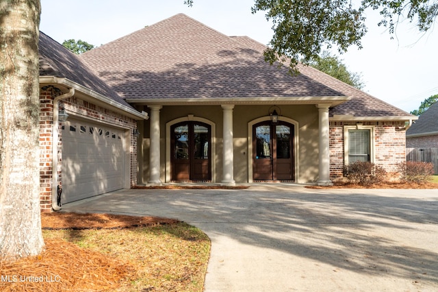 view of front of home with a garage and french doors