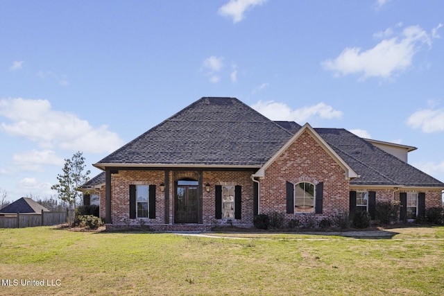 view of front of property featuring brick siding, a front yard, fence, and a shingled roof