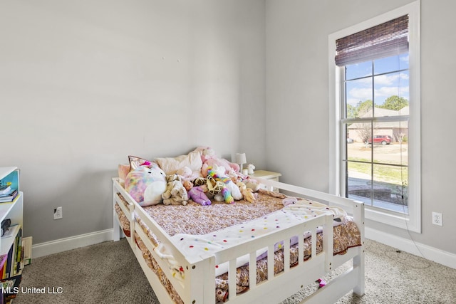 carpeted bedroom featuring multiple windows and baseboards