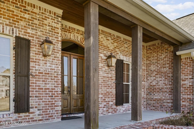 view of exterior entry with french doors and brick siding