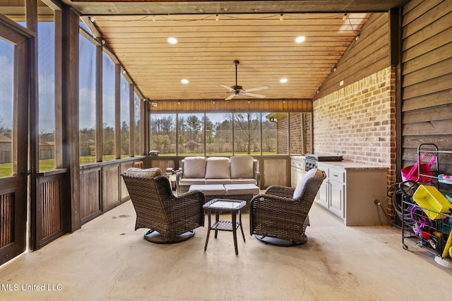 sunroom / solarium featuring lofted ceiling, ceiling fan, and wood ceiling