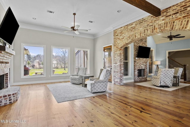 living area with a brick fireplace, visible vents, and a healthy amount of sunlight