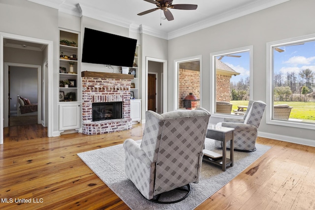 living room featuring ornamental molding, hardwood / wood-style floors, a brick fireplace, and built in features