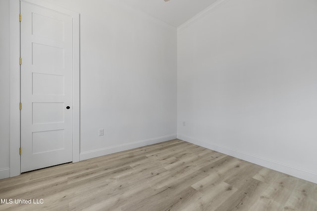 unfurnished room featuring ornamental molding and light hardwood / wood-style flooring