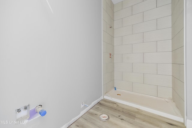 bathroom featuring hardwood / wood-style flooring and tiled shower