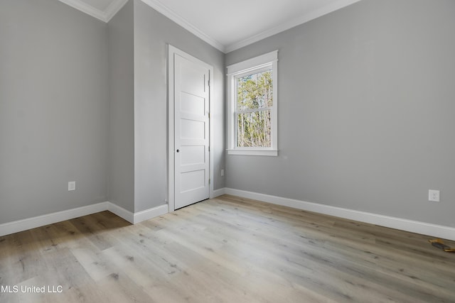 unfurnished room with ornamental molding and light wood-type flooring