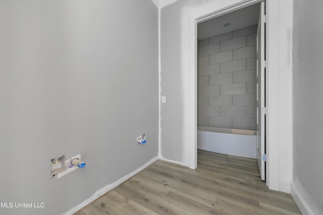 clothes washing area with light hardwood / wood-style flooring