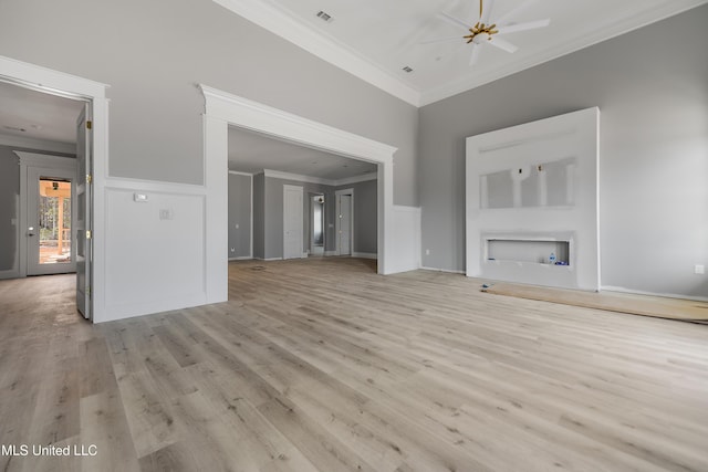 unfurnished living room with ceiling fan, ornamental molding, and light hardwood / wood-style flooring