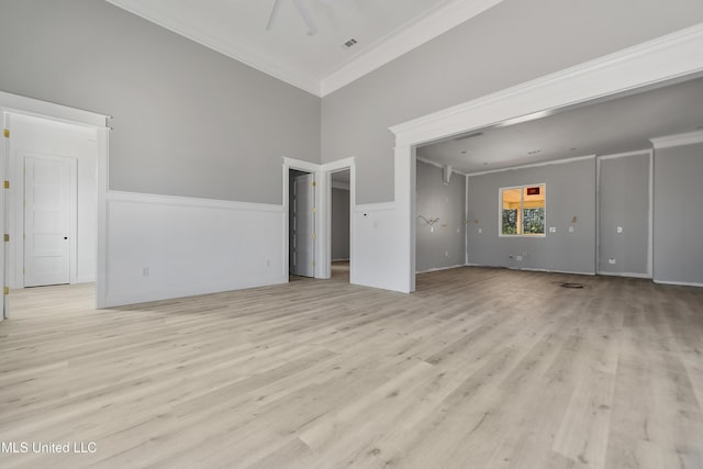 unfurnished living room featuring crown molding and light wood-type flooring