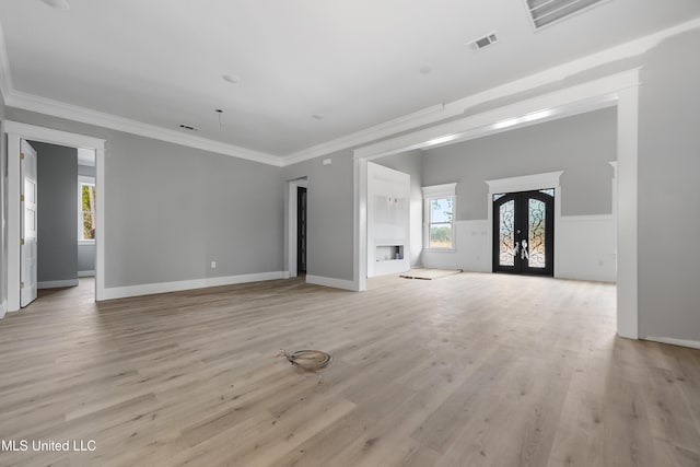 unfurnished living room featuring ornamental molding, light hardwood / wood-style floors, and french doors