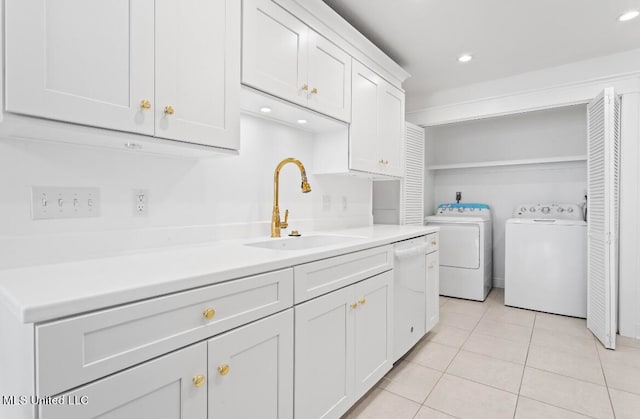 laundry room featuring light tile patterned flooring, sink, and washing machine and dryer