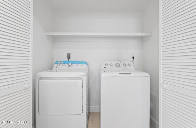 washroom with separate washer and dryer and light tile patterned floors