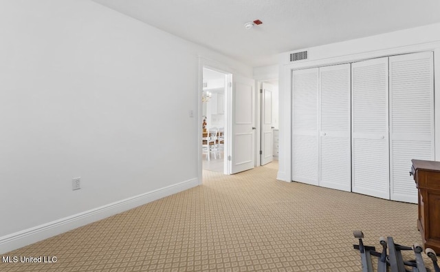 unfurnished bedroom featuring light carpet and a closet