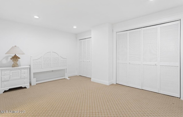 unfurnished bedroom with two closets and carpet floors