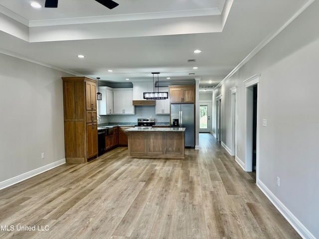 kitchen featuring light wood-type flooring, stainless steel appliances, pendant lighting, crown molding, and a center island