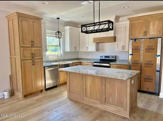 kitchen featuring appliances with stainless steel finishes, a center island, decorative light fixtures, light stone counters, and light hardwood / wood-style flooring