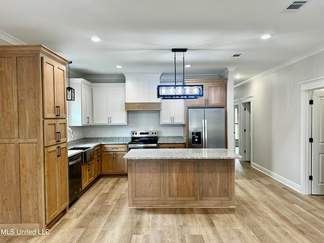 kitchen with white cabinets, a kitchen island, stainless steel appliances, light hardwood / wood-style floors, and decorative light fixtures