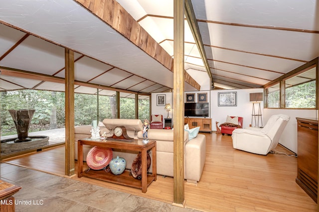 living area with wood finished floors and lofted ceiling with beams