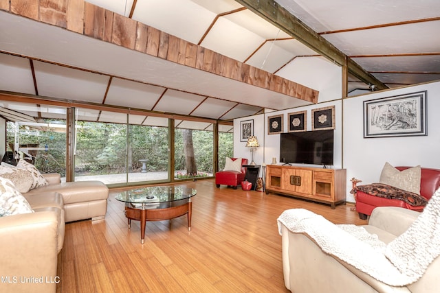 living area featuring wood finished floors, vaulted ceiling with beams, and a wall of windows