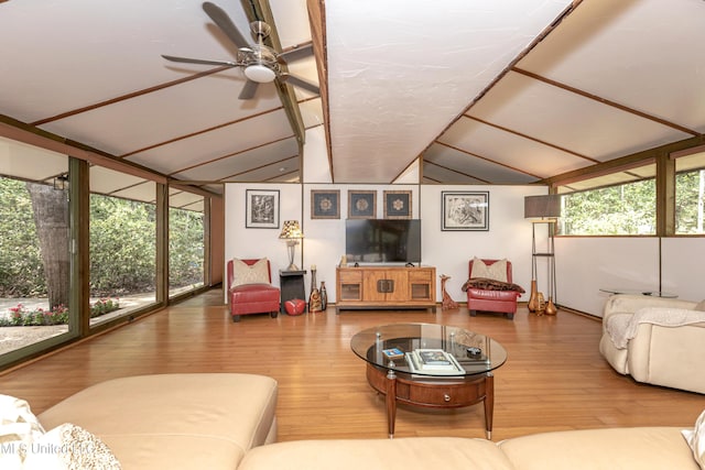 living area featuring vaulted ceiling, wood finished floors, a wealth of natural light, and a ceiling fan